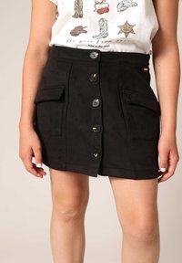 Zwarte suede rok met een knoopsluiting aan de voorkant, twee opgestikte zakken en een lichte flair. Bevat glanzende zwarte knopen en een gladde textuur.