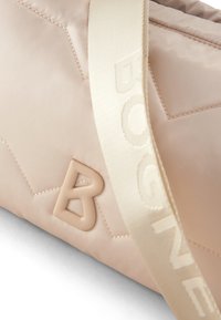 Borsa trapuntata beige con superficie testurizzata, dotata di un logo in gomma a forma di 'B' e di una larga tracolla crema ricamata con "BOGNE."