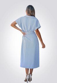 Vestido de algodón azul a rayas con cinturón en la cintura, mangas cortas y largo hasta la mitad de la pantorrilla, con un corte relajado y pliegue en la parte posterior.