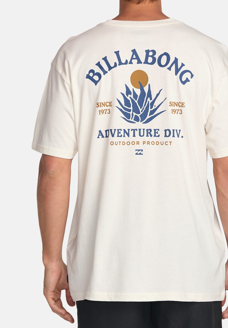 Kreemivärvi T-särk, millel on sinine ja kuldne graafiline tekst "BILLABONG ADVENTURE DIV." koos agave taime ja päikese illustratsiooniga.
