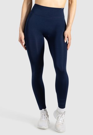 Marineblauwe high-waisted leggings gemaakt van een soepele, rekbare stof. Bevat een naadloos ontwerp zonder zichtbare hardware of patronen.