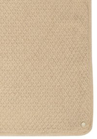 Beżowa pikowana mata o teksturowanej powierzchni i obramowaniu, z pojedynczym dekoracyjnym guzikiem w dolnym prawym rogu.