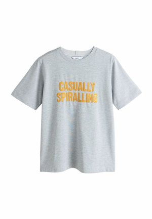 Helehall hall lühikeste varrukatega T-särk kollase tikandiga tekstiga "CASUALLY SPIRALLING" ees, ümmarguse kaelusega, lihtsa taustaga.