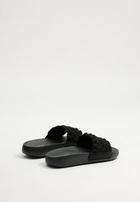 Sandalias negras de slip-on con correas de textil trenzadas, suelas de goma texturizadas y un acabado suave. Diseño ligero con forma ergonómica.