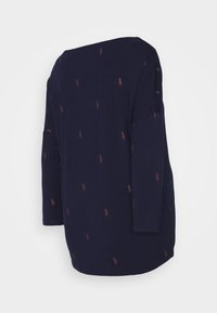 Námořnická modrá halenka s dlouhým rukávem a volným střihem, s malými vzory listů v rezavé barvě a knoflíkovými detaily na rameni. Měkká textilie.