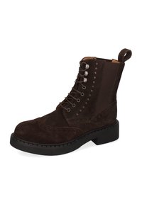 Brązowy zamszowy botek za kostkę z sznurowaniem, okrągłym noskiem, boczną elastyczną wstawką, detalami w stylu brogue oraz masywną czarną gumową podeszwą.