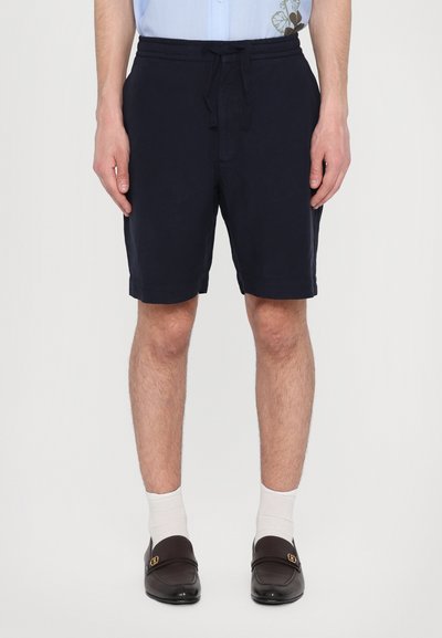 Pantalones cortos azul marino con un corte relajado, cinturilla elástica y cordón. Fabricados en un tejido ligero con una textura suave.