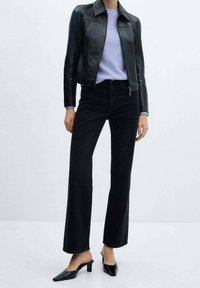 Czarna skórzana kurtka, jasnoniebieski prążkowany sweter, czarne dżinsy z wysokim stanem i rozszerzanymi nogawkami, czarne mule na niskim obcasie, casualowy zestaw.