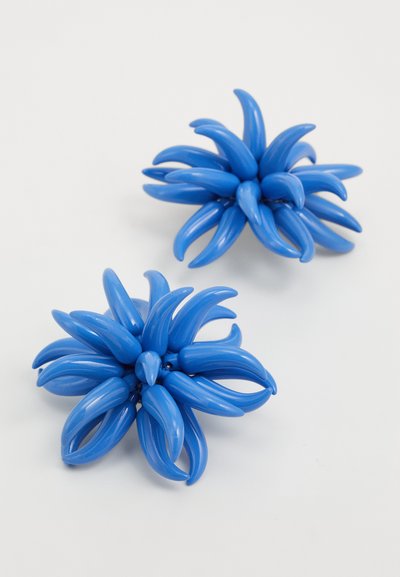 Accesorios para el cabello en forma de flor de plástico azul, con múltiples pétalos alargados, acabado brillante, que presentan dos piezas distintas de tamaño variable.