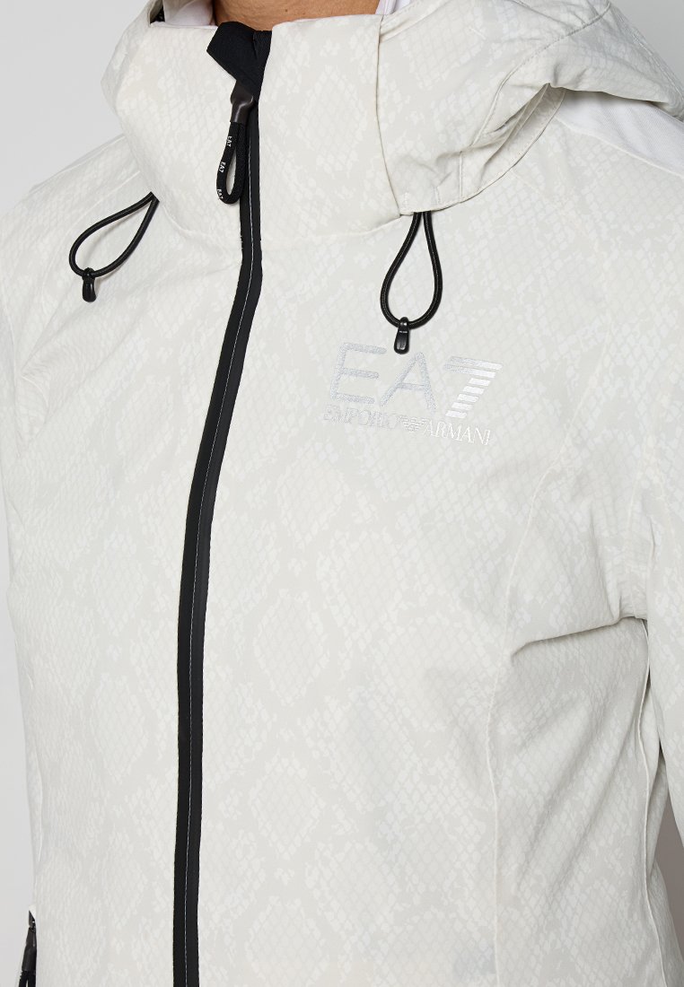 Leichte Kapuzenjacke in Off-White mit einer subtilen Schlangenledertextur. Verfügt über schwarze Reißverschlüsse und Kordelzüge sowie reflektierende Logodetails.