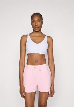 Sujetador deportivo de color púrpura claro con tirantes gruesos y escote en forma de V, combinado con pantalones cortos rosas con cordón y textura suave.