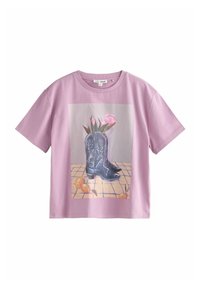 Light pink short-sleeve T-shirt featuring a front graphic of black cowboy boots with floral accents and a tiled background.