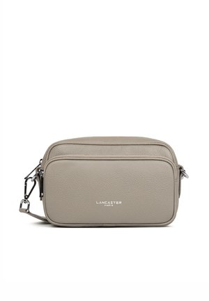 Sac bandoulière rectangulaire beige texturé avec poche avant zippée, fermoirs argentés et logo "Lancaster Paris" au centre devant.
