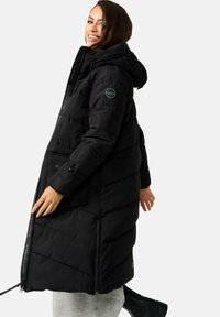 Czarna puchowa kurtka z kapturem, z poziomym przeszyciem, z zamykanymi kieszeniami po bokach oraz detalem logo na rękawie i zamku.