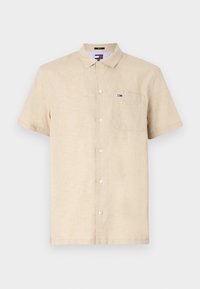 Beige kortermet skjorte laget av lin med krage som kan kneppes, med en lomme på venstre bryst og et lite logo-patch.