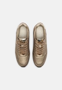 Guldskor med texturerad yta, platta snören och metalliska detaljer; har en vadderad innersula och en rundad tådesign.