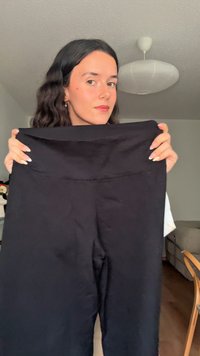 Črne pajkice z širokim pasom, gladke teksture in preprostega dizajna. Tkanina je videti raztegljiva in anatomsko prilegajoča.