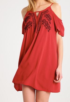 Rode off-shoulder jurk met zwarte geborduurde details en een keyhole-halslijn. Gemaakt van lichtgewicht, gestructureerde stof met een losse pasvorm.