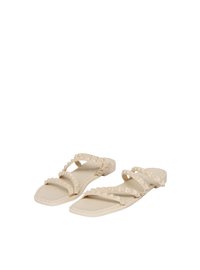 Sandali piatti beige con due fasce larghe, decorati con piccoli chiodi a piramide, punta quadrata e una superficie liscia simile alla gomma.