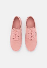 Sneakers in tela rosa chiaro con punta rotonda, design con lacci e suola in gomma bianca. Presentano un logo sul lato e cuciture a contrasto.