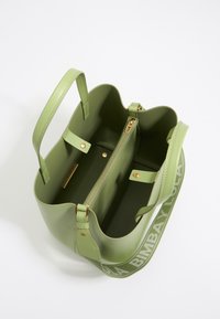 Green faux leather handbag with dual handles, interior zip pocket, and logo-printed strap. Smooth texture and structured shape.