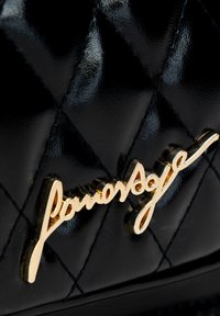 Zwarte gewatteerde handtas van lakleder, met een opvallend gouden logoaccent. Gladde textuur met een diamantpatroon in de stikking.
