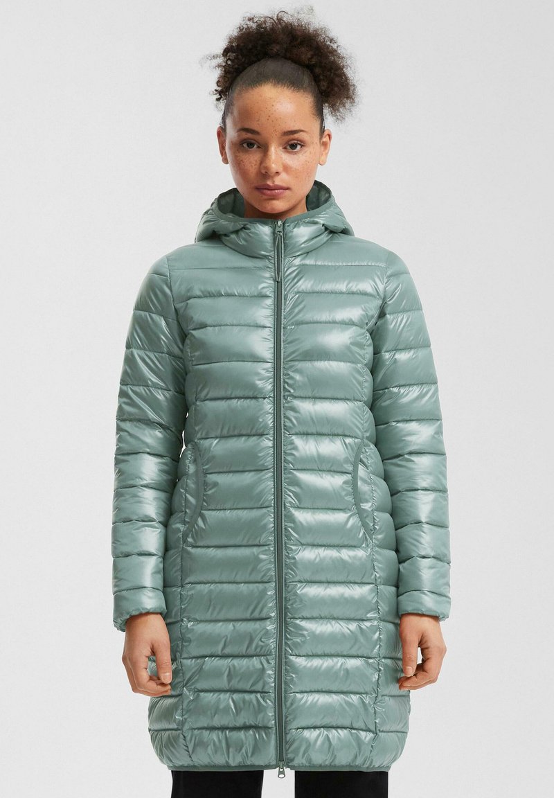 Chaqueta acolchada con capucha en verde claro y acabado brillante, con bafles horizontales, cierre frontal de cremallera y bolsillos laterales.