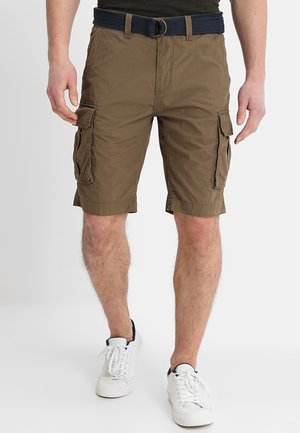 Brune cargoshorts med et tekstureret stof, der har flere sidelommer og et sort bælte. Kombineret med hvide sneakers fuldender looket.
