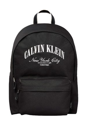 Sac à dos noir Calvin Klein avec poche à fermeture éclair à l'avant et texte blanc "Calvin Klein New York City Established in 1968" sur le panneau avant.