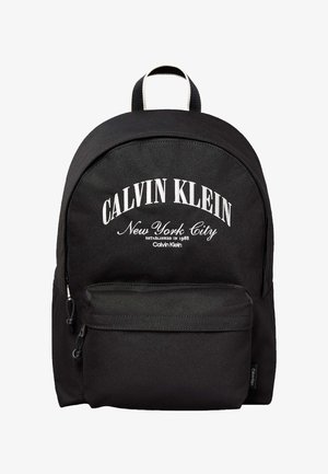 Czarny plecak Calvin Klein z przednią kieszenią na zamek i białym napisem "Calvin Klein New York City Established in 1968" na przednim panelu.