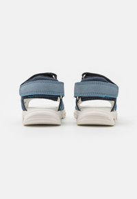 Sandal blu e blu scuro con retro chiuso, cinturini regolabili e suola in gomma bianca. Materiali in pelle liscia e rete traspirante.