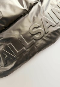 Schwarze Pufferjacke mit glänzender Oberfläche und hervorgehobenem "ALLSAINTS"-Branding. Das Material ist glatt und verfügt über dezente Nähte.