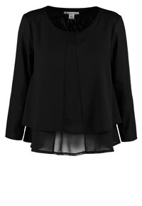Maglia nera a maniche lunghe con un design a strati e orlo curvo. Lo strato esterno è opaco e lo strato interno è in tessuto trasparente.