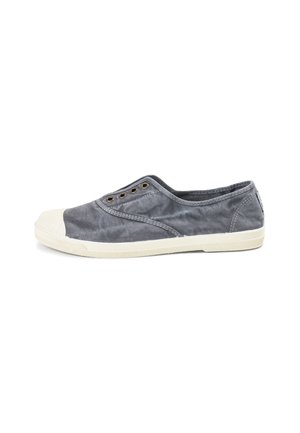 Zapato slip-on de lona gris con acabado texturizado, puntera de goma y cinco ojales metálicos para los cordones. Diseño ligero y casual.