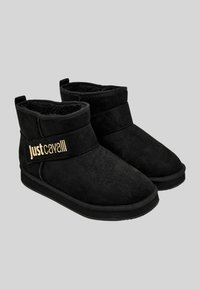 Stivaletti neri alla caviglia in morbido suede con una fodera soffice, dotati di una larga fascia in velcro e del logo dorato "Just Cavalli".