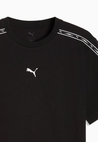 Μαύρο μπλουζάκι Puma με λευκό λογότυπο Puma στο στήθος και διακοσμητική λευκή ρίγα με την επωνυμία κατά μήκος των ώμων.