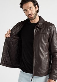 Braune Lederjacke mit glatter Oberfläche, gestepptem Futter und einem Frontreißverschluss. Sie verfügt über einen klassischen Kragen und Seitentaschen.