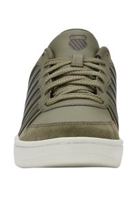 K-Swiss Sneaker aus olivgrünem Leder und Wildleder. Mit weißer Gummisohle, grauen Streifen und strukturierten Schnürsenkeln. Einfaches, niedrig geschnittenes Design.