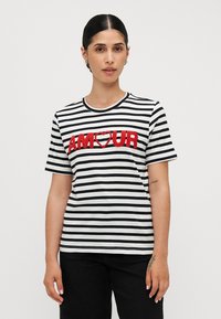 Randig t-shirt med kort ärm i svart och vitt, med texturerad r�öd "AMOUR"-bokstavering och ett hjärta, rund halsringning och avslappnad passform.