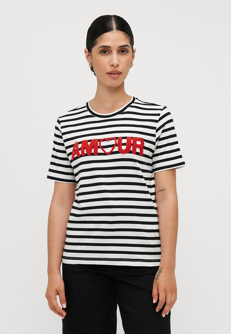 Randig t-shirt med kort ärm i svart och vitt, med texturerad röd "AMOUR"-bokstavering och ett hjärta, rund halsringning och avslappnad passform.