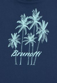 Tamno plava majica s kratkim rukavima s grafikom svijetloplavog palminog drveta i natpisom "Brunotti" u podebljanom, rukopisnom fontu ispod.