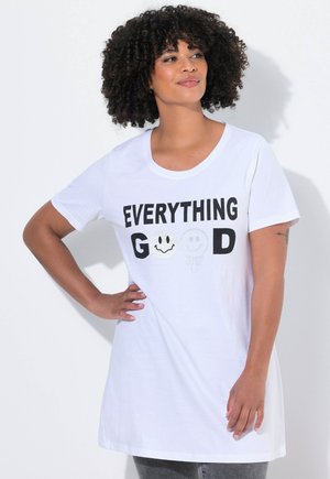 Camiseta blanca de manga corta con texto negro que dice "TODO BIEN" acompañado de gráficos de caras sonrientes. Tejido suave y ajuste relajado.