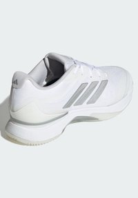 Biały but sportowy z teksturowaną siateczkową cholewką, szarymi akcentami oraz amortyzowaną podeszwą z trwałym gumowym bieżnikiem.