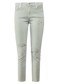 Vaaleanvihreät farkkulegginsit, joissa on kulutustehotetut repeämät polvissa, viiden taskun muotoilu sekä perinteinen nappi- ja vetoketjusuljenta.