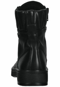 Botín negro de cuero hasta el tobillo con puño acolchado y cremallera lateral. Presenta una suela de goma negra sólida y una textura mate suave.
