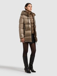 Luftig, lys brun dunjakke med hætte og lynlåse, båret over en mørkere inderjakke. Sorte knælange støvler med hæl fuldender outfittet.