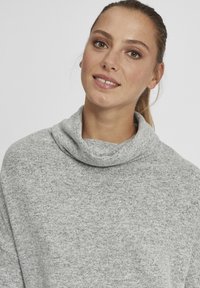 Maglione grigio a collo alto realizzato in un morbido tessuto testurizzato. Presenta una vestibilità comoda e un delicato motivo melange con un collo ampio.