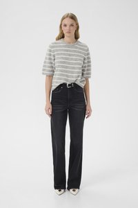 Grå stripete genser med korte ermer kombinert med svarte høytlivsjeans og hvite sko med spiss tå og hjerteformede detaljer.