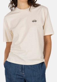 Cotton T-shirt in off-white featuring a small embroidered bicycle with daisies. Relaxed fit with short sleeves and a round neckline.