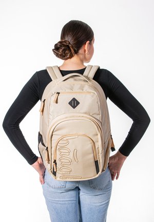 Beige Rucksack aus strukturiertem Stoff, mit zwei Reißverschlussfächern und einem hervorgehobenen Design auf der Vorderseite. Verfügt über verstellbare Träger und ein rautenförmiges Logopatch.